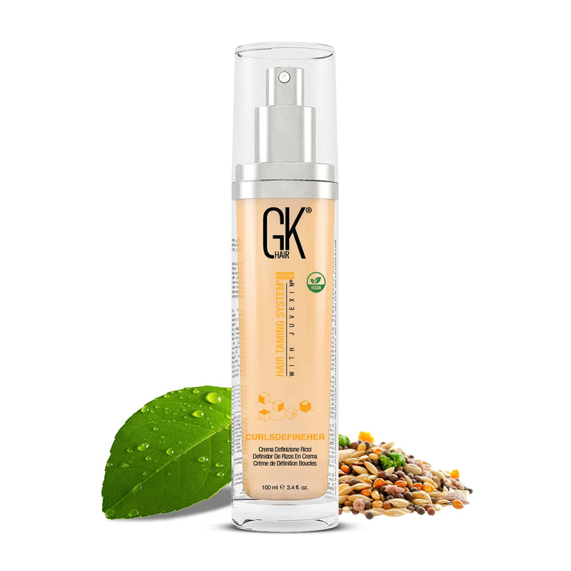 GK Hair CurlsDefineHer curl definition cream 100 ml pump bottle beside a green leaf and mixed seeds