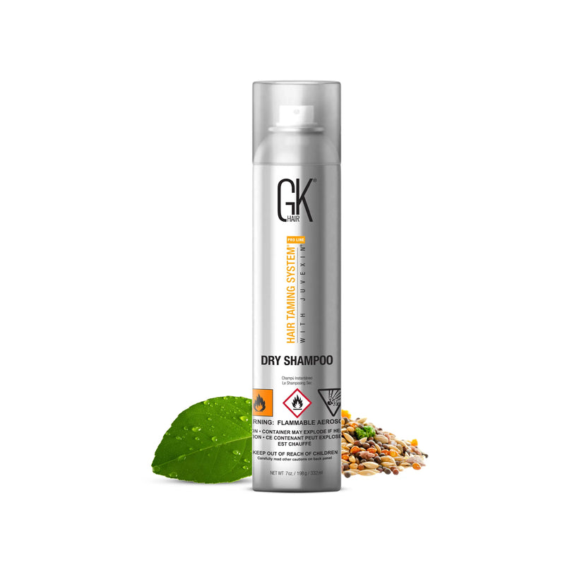 GK Hair Dry Shampoo 332 ml silver aerosol can on white, with a green leaf and scattered seeds beside it