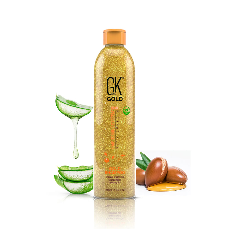 GK Hair Gold Shampoo 250 ml glittering gold bottle on white, flanked by sliced aloe vera and argan nuts in oil