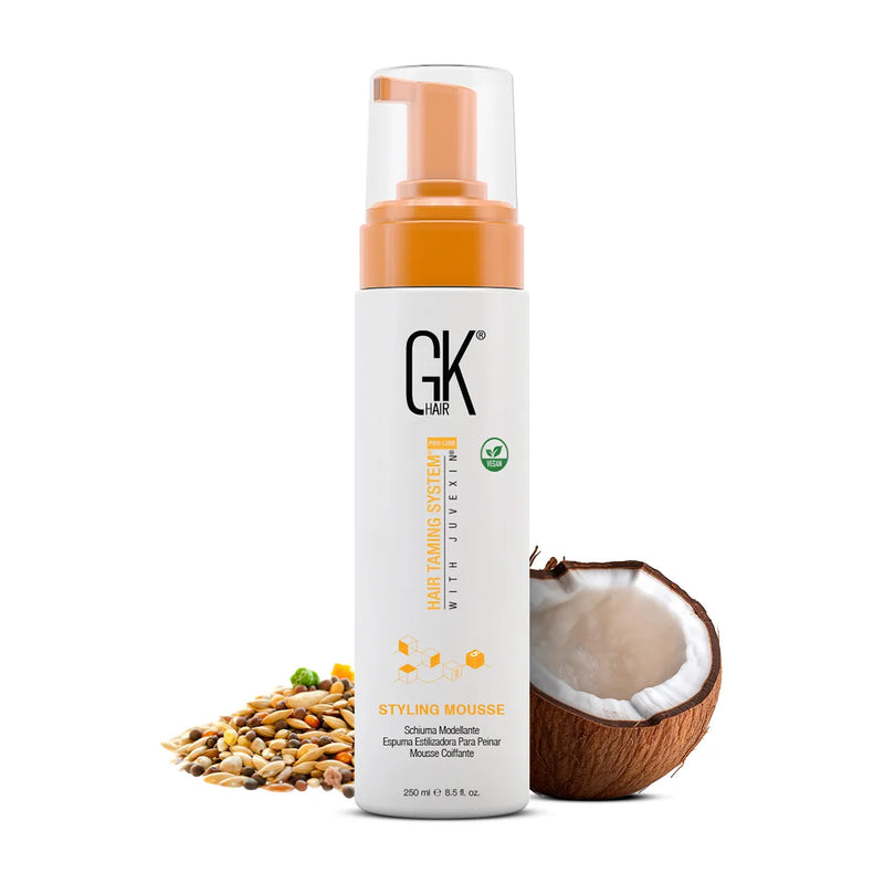 GK Hair Styling Mousse Pro 250 ml pump bottle shown with a halved coconut and natural seeds on a white background