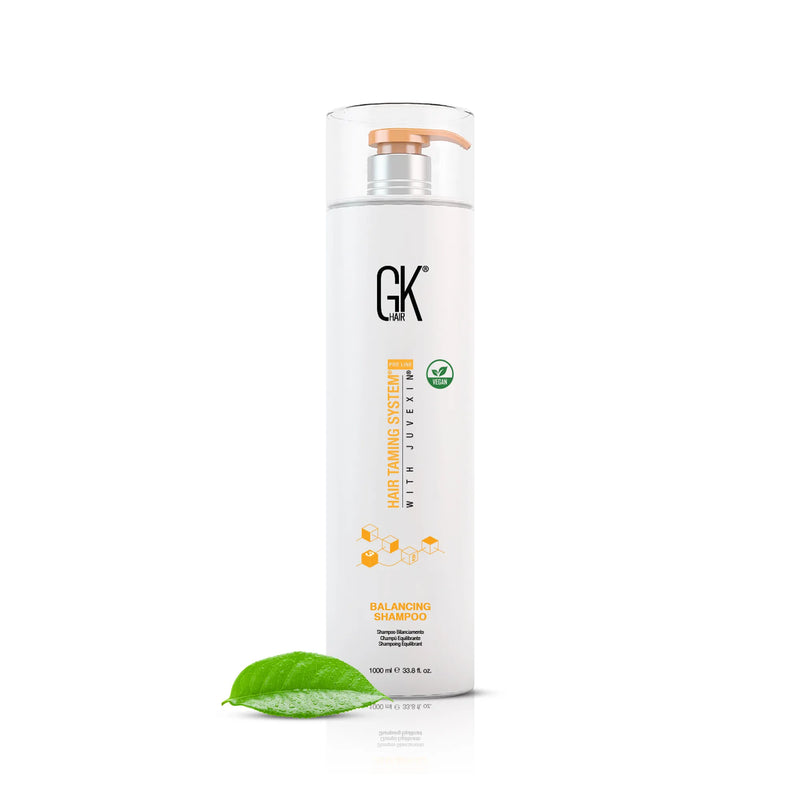 GK Hair Balancing Shampoo 1000 ml bottle with a copper pump, shown beside a green leaf on a white background