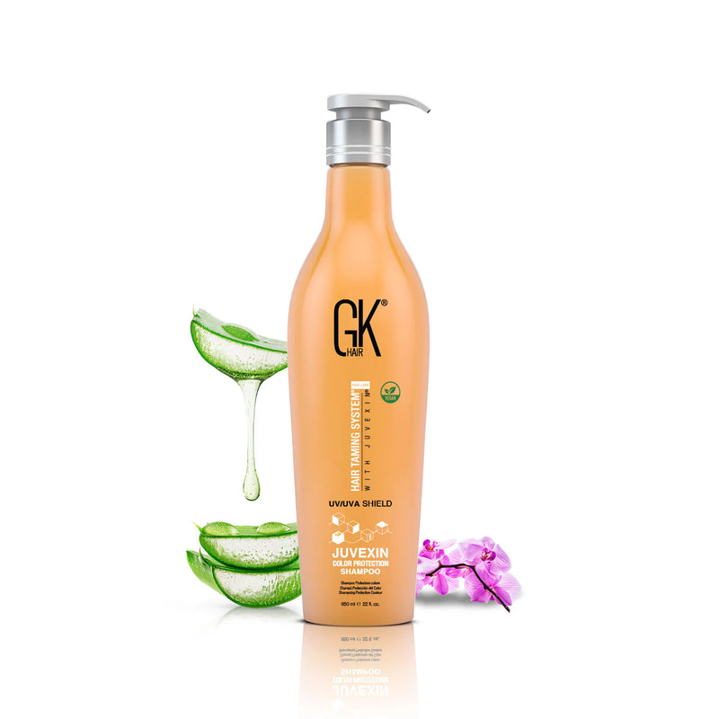 GK Hair Shield Shampoo in the 650 ml orange pump bottle, beside dripping aloe vera and a purple orchid